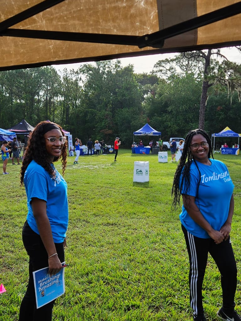 Staff members in tomlinson dental t-shirts smiling at camera