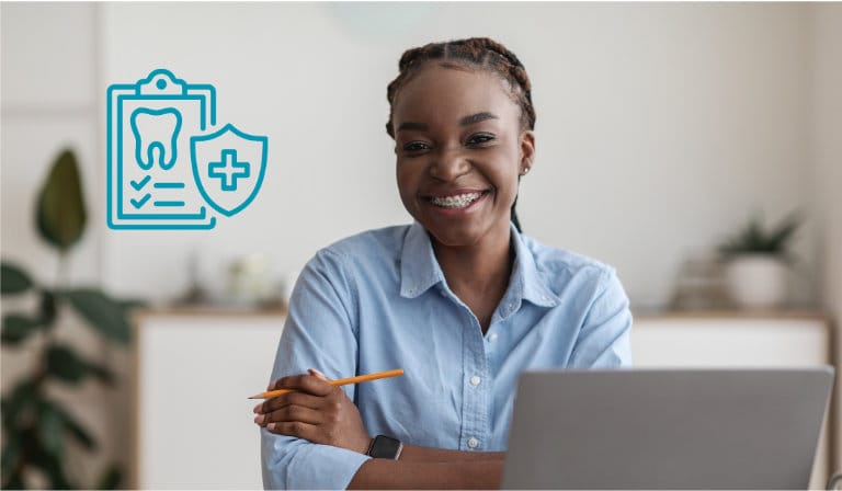 A cheerful woman looks at her laptop, featuring a dental care icon, highlighting her interest in dental health.
