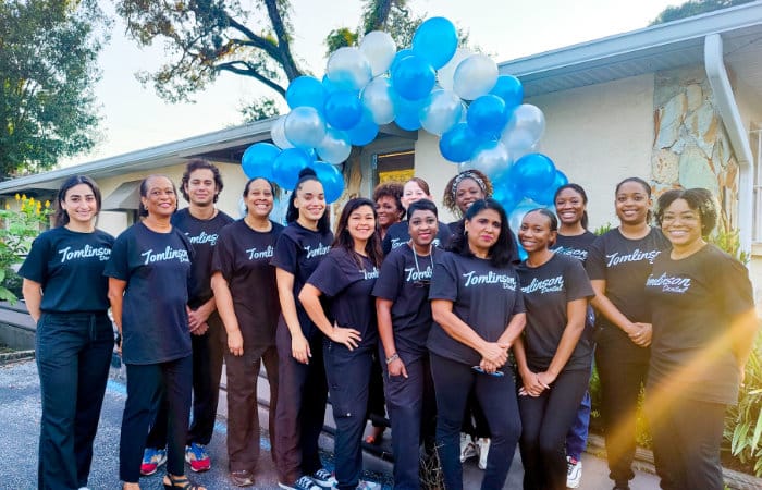 Group Picture with everyone standing in front of an outdoor tent as they check-in patients for their September Smiles Event